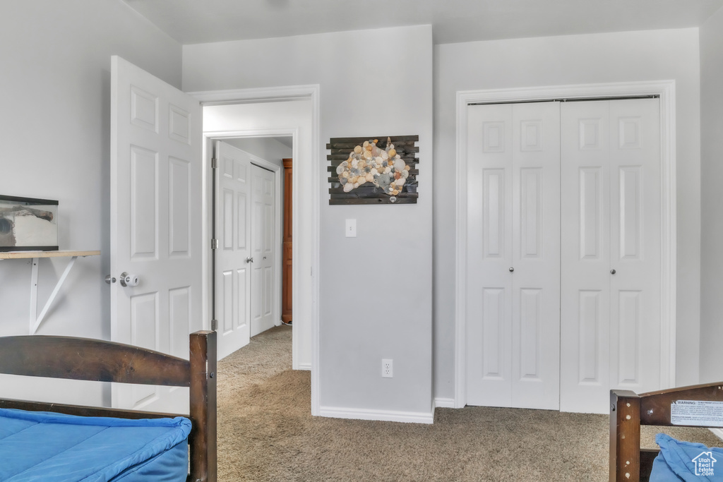 Carpeted bedroom featuring a closet and baseboards