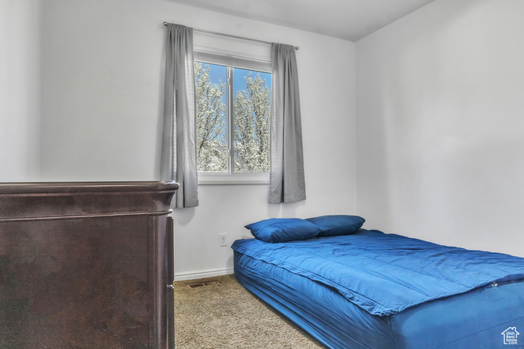 Carpeted bedroom featuring baseboards and visible vents