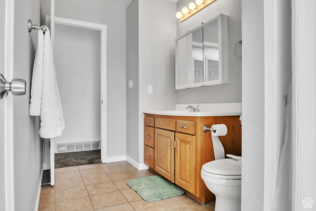 Bathroom with vanity, tile patterned flooring, visible vents, toilet, and baseboards