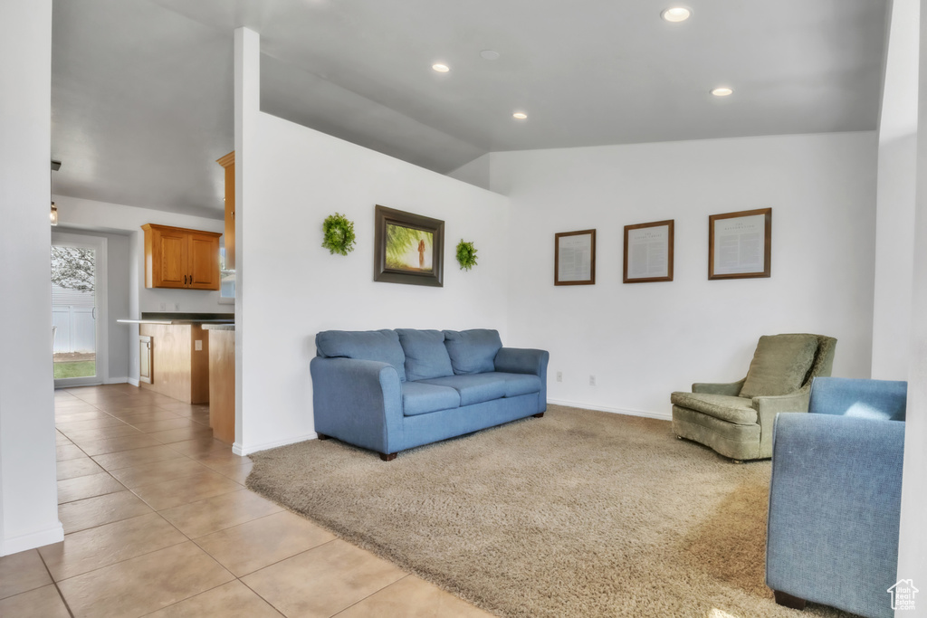 Living area with light tile patterned flooring, baseboards, lofted ceiling, and recessed lighting
