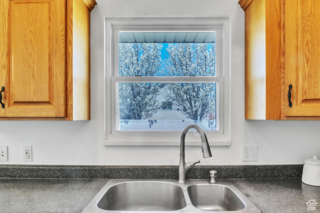 Room details featuring brown cabinets, a sink, and dark countertops