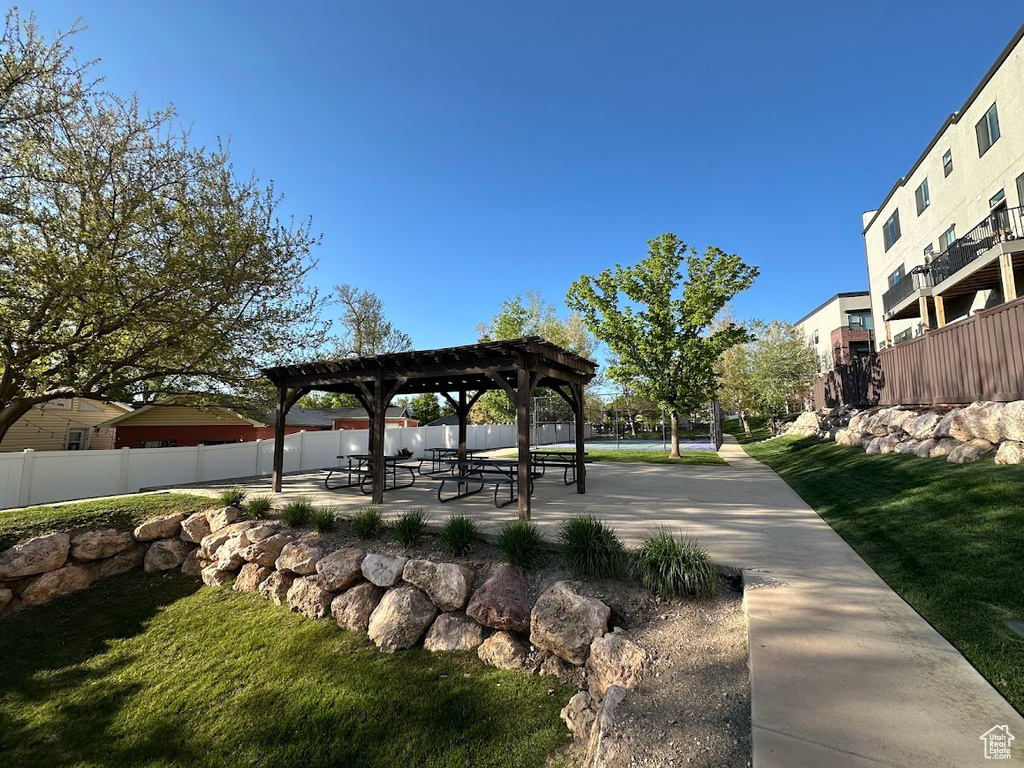 View of property's community featuring a pergola, fence, a patio, and a lawn