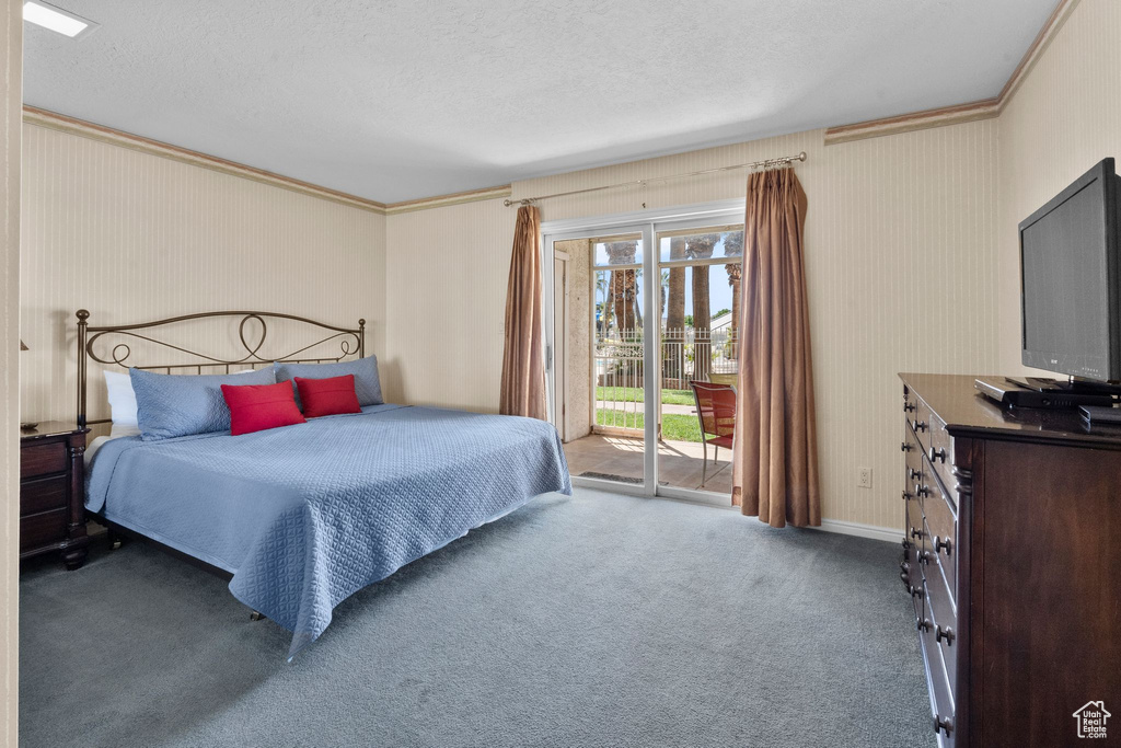 Carpeted bedroom with access to outside, a textured ceiling, crown molding, and baseboards