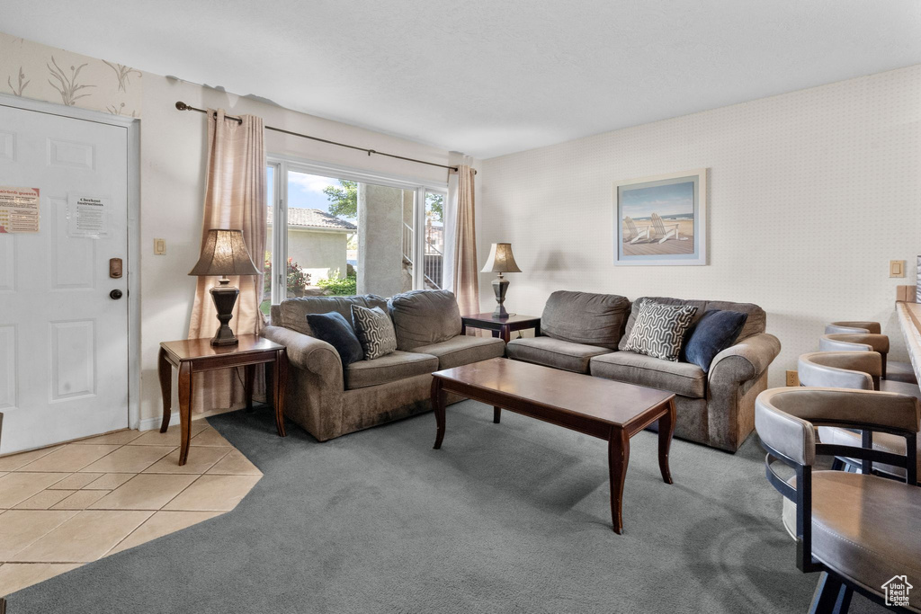 Living room with light colored carpet, light tile patterned floors, and wallpapered walls