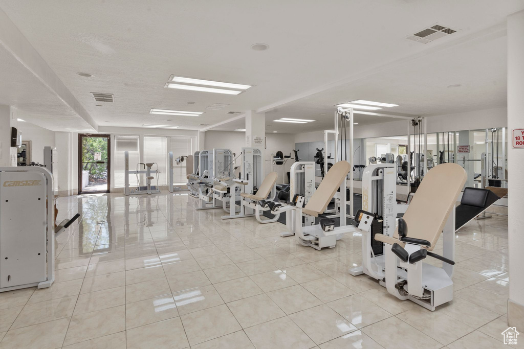 Exercise room featuring light tile patterned floors and visible vents