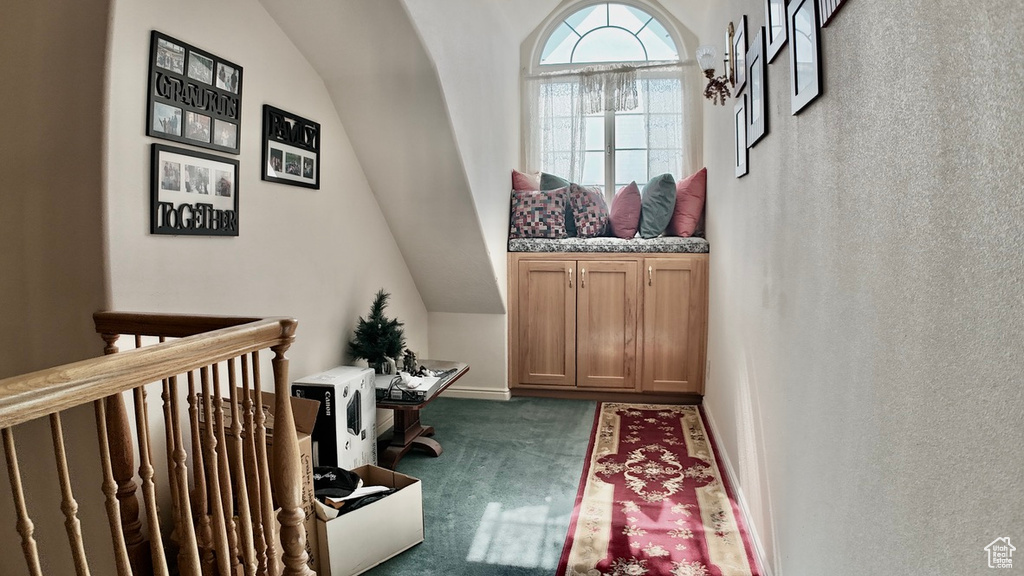Doorway featuring carpet and lofted ceiling