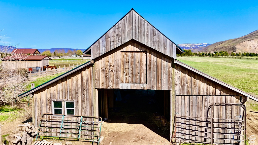 View of barn featuring a yard and a mountain view