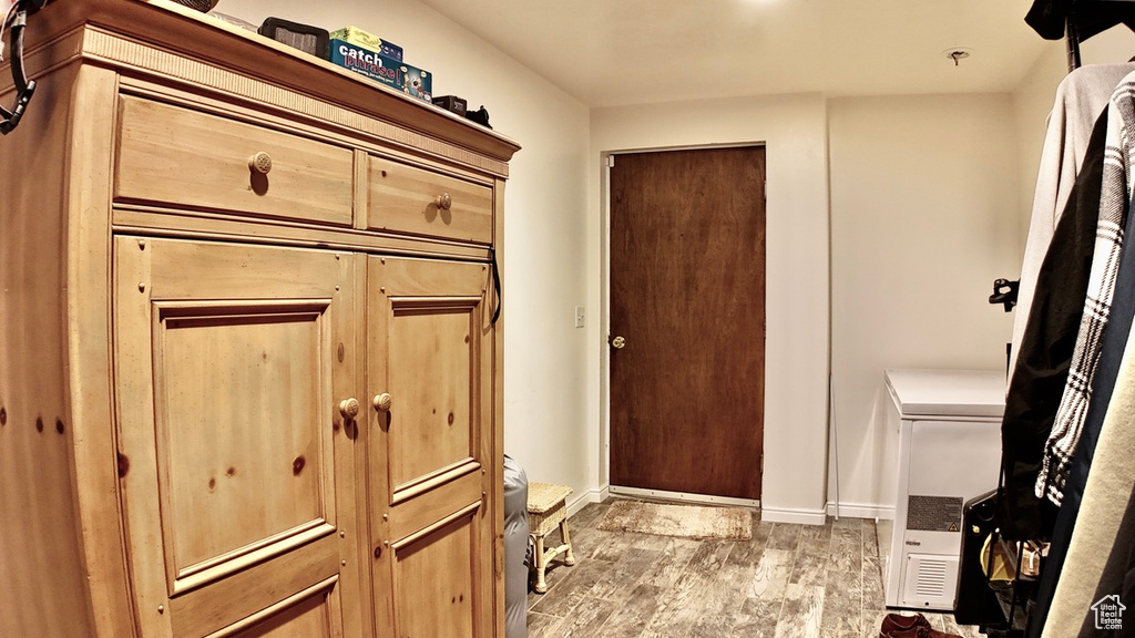 Interior space with baseboards, toilet, and wood finished floors