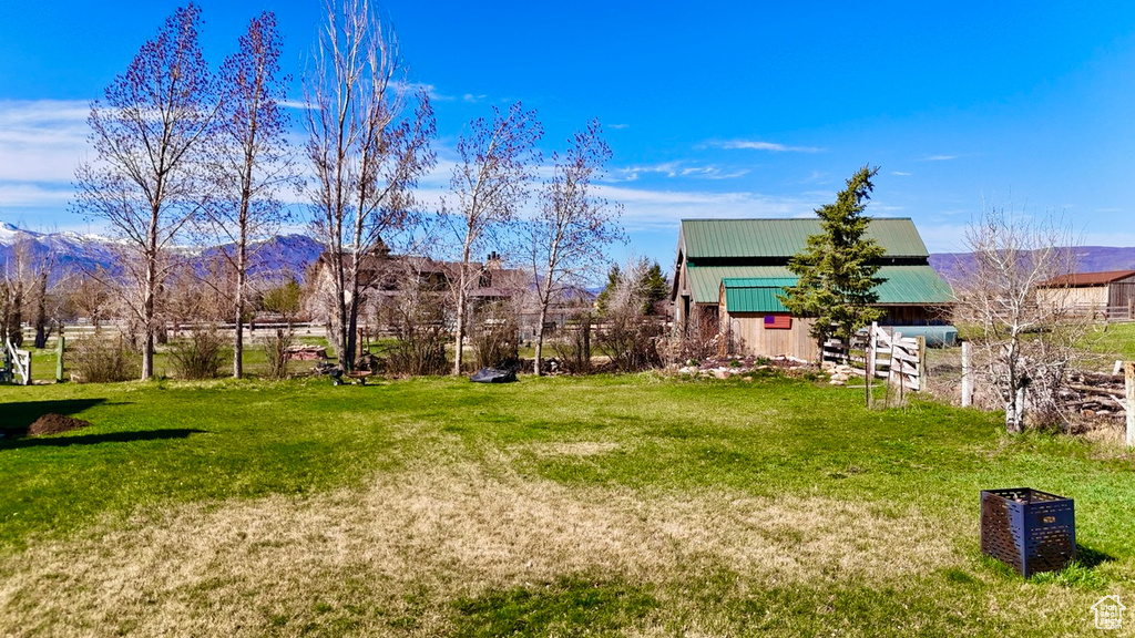 View of yard featuring an outbuilding, a mountain view, and an outdoor structure