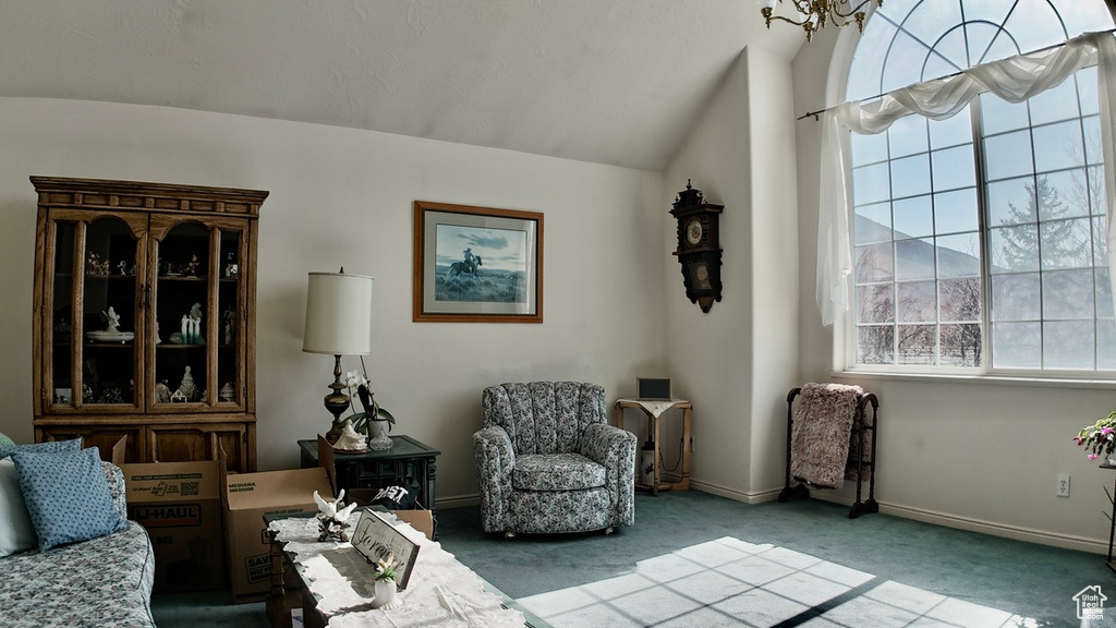 Living area with baseboards, carpet, and vaulted ceiling