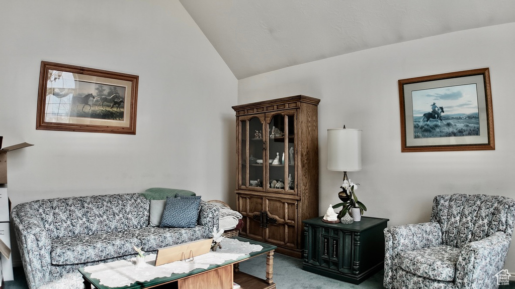 Living area with carpet floors and lofted ceiling
