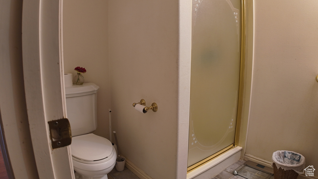 Full bathroom featuring tile patterned floors, a stall shower, and toilet