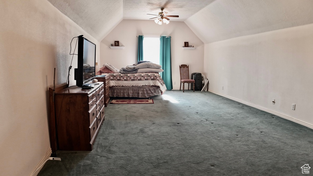 Bedroom with baseboards, a ceiling fan, carpet, a textured ceiling, and vaulted ceiling