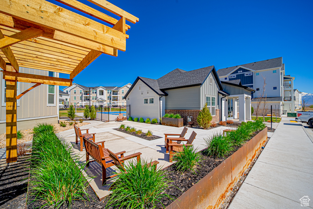 View of patio / terrace with a pergola, fence, and a residential view