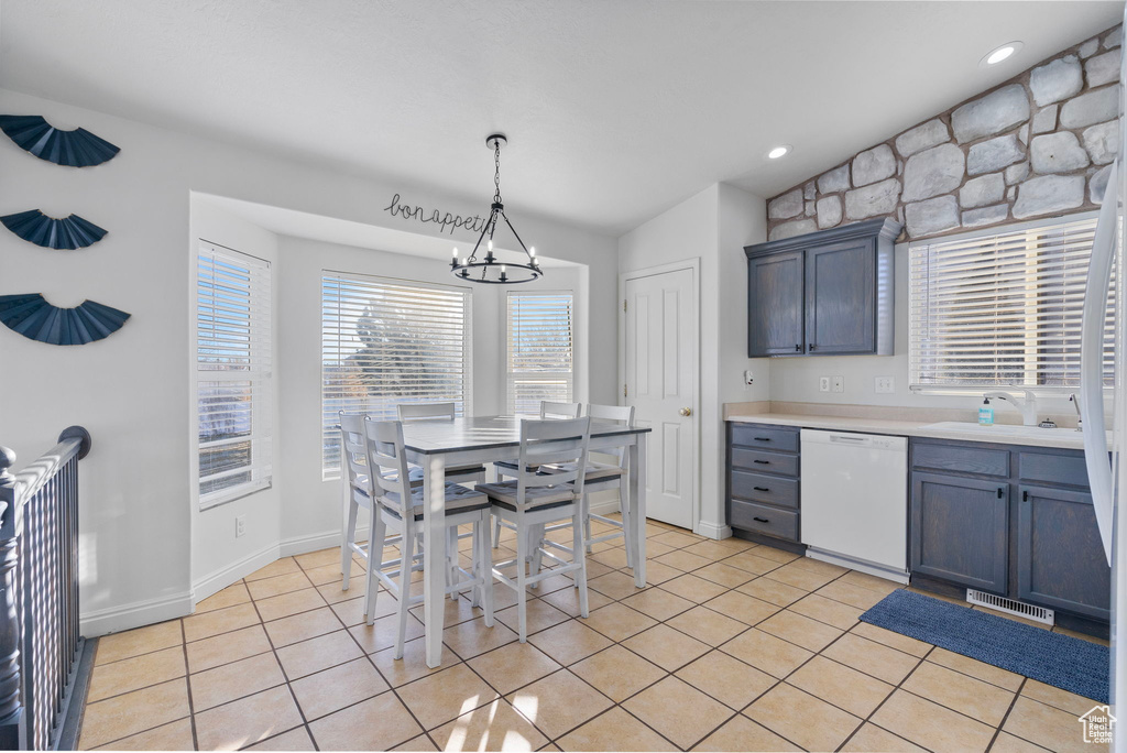 Kitchen with visible vents, light tile patterned flooring, a sink, dishwasher, and a notable chandelier