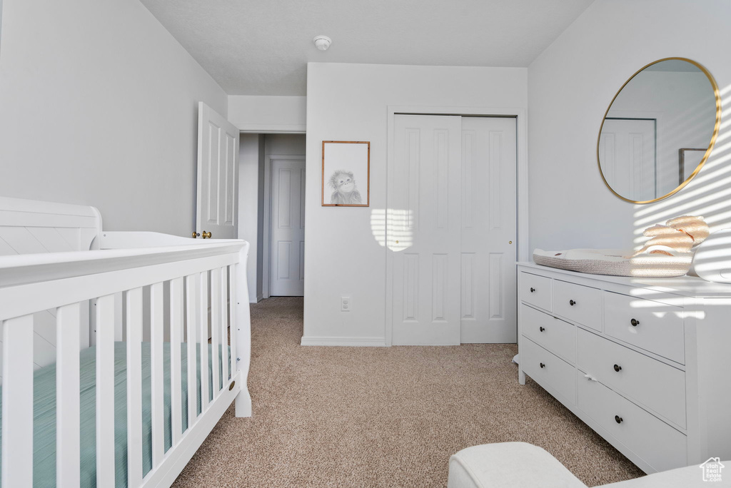 Bedroom featuring light carpet and a closet
