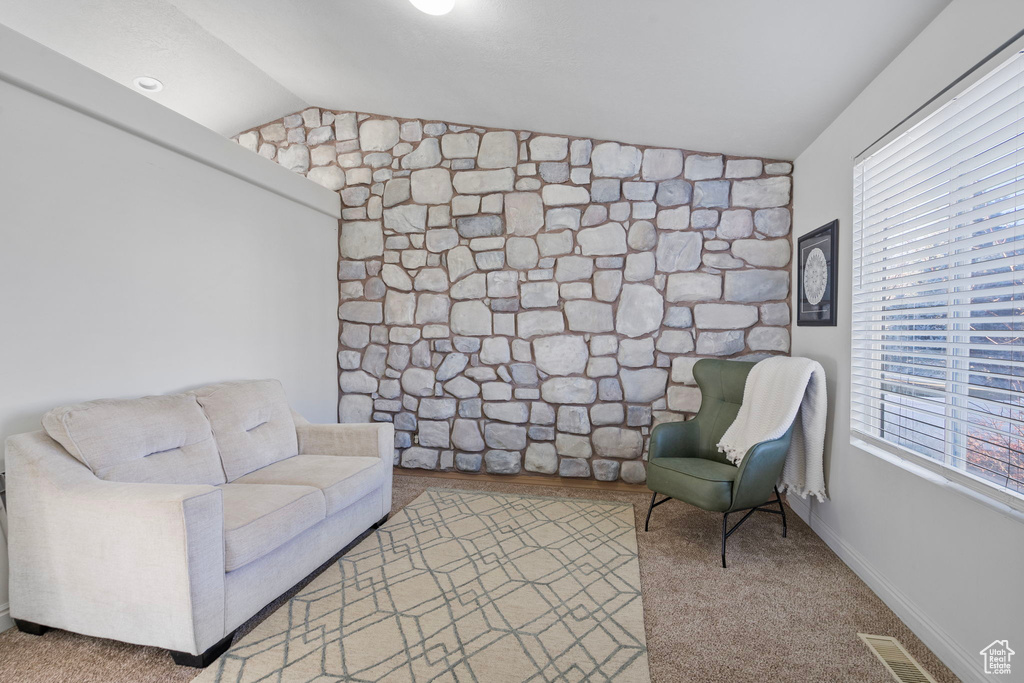 Sitting room with carpet, visible vents, and lofted ceiling