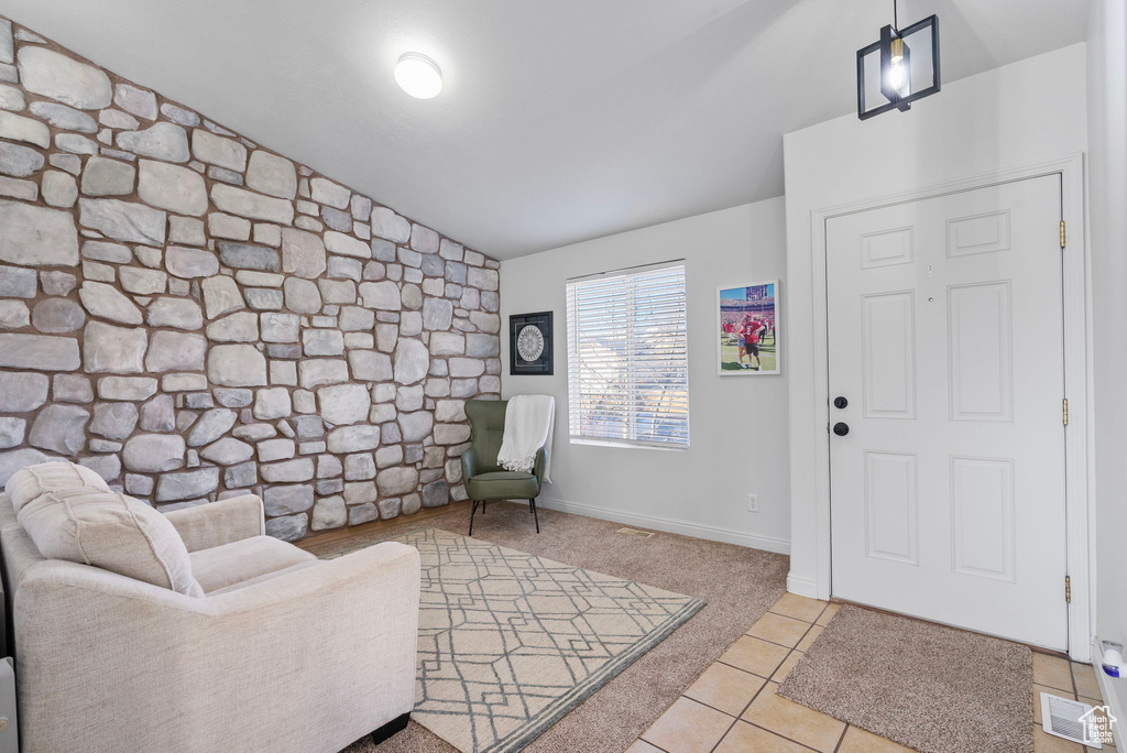 Foyer entrance featuring light tile patterned floors and lofted ceiling