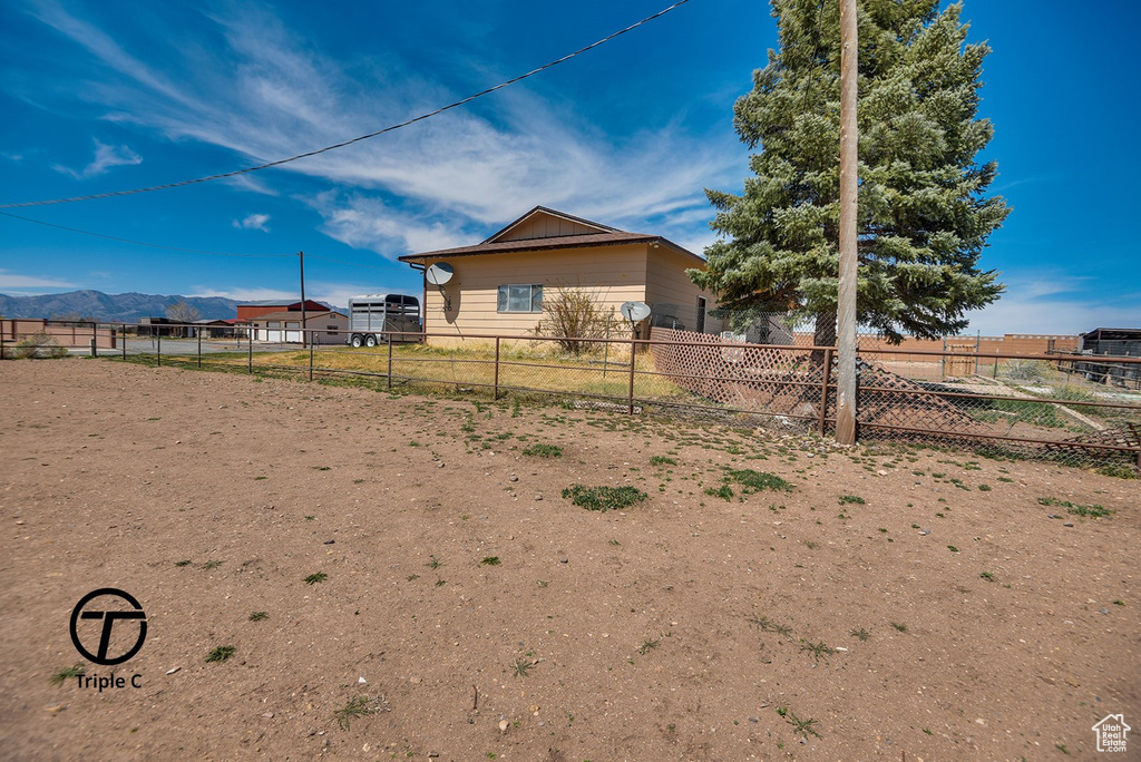 View of yard with a mountain view and fence