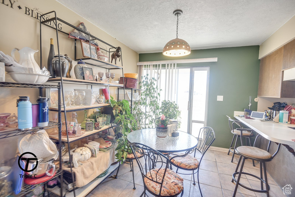 Dining room with light tile patterned flooring and a textured ceiling