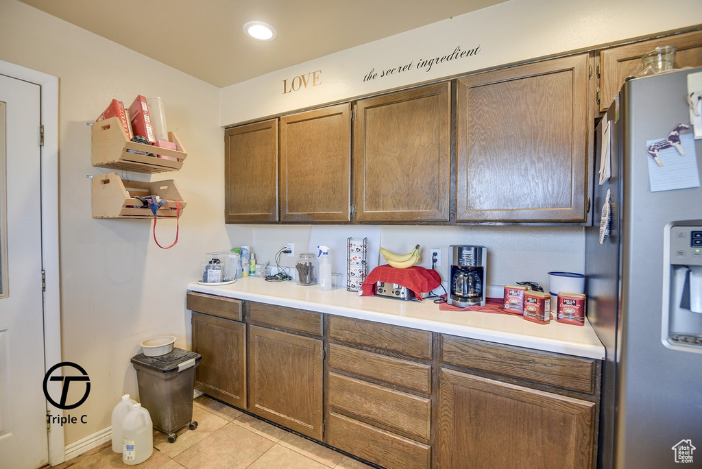 Kitchen featuring light tile patterned flooring, light countertops, stainless steel fridge, and recessed lighting