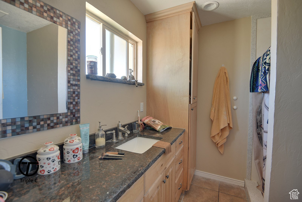 Bathroom featuring tile patterned floors, vanity, and baseboards