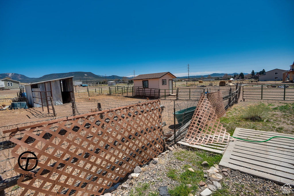 View of yard with an outbuilding, a mountain view, and an exterior structure