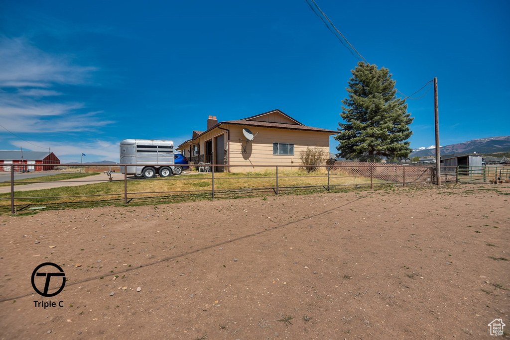 Exterior space with a chimney, fence, and concrete driveway