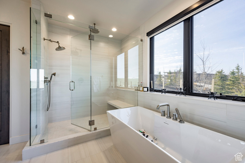 Full bath with a shower stall, a freestanding tub, tile patterned floors, and recessed lighting