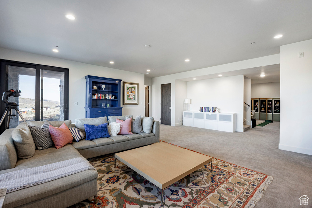Carpeted living area featuring baseboards, stairway, and recessed lighting