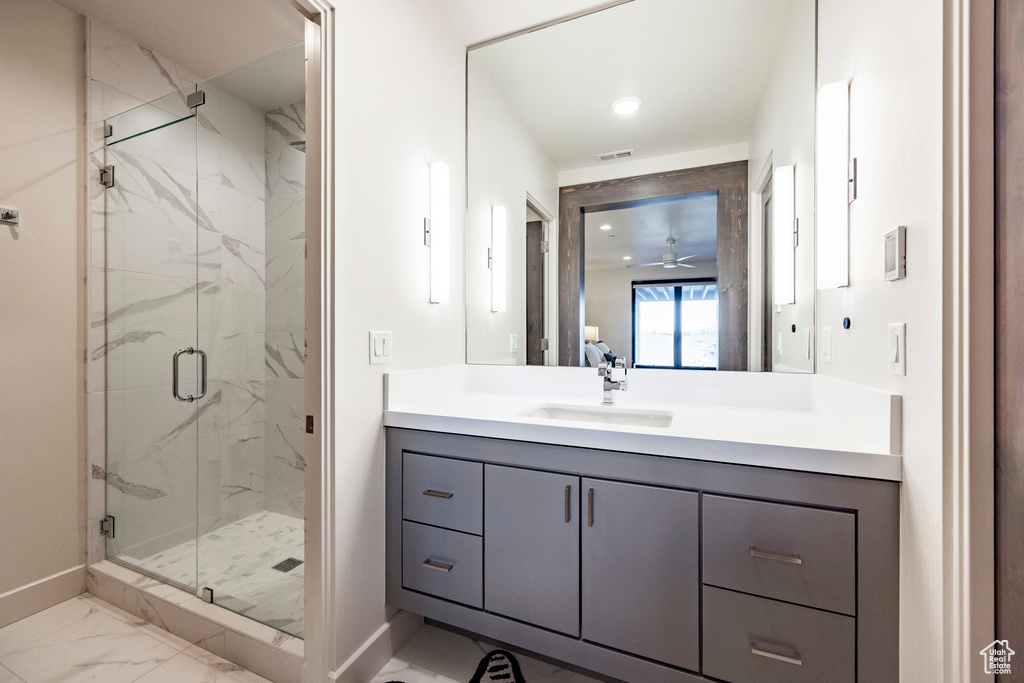 Full bathroom with visible vents, baseboards, vanity, a marble finish shower, and marble finish floor