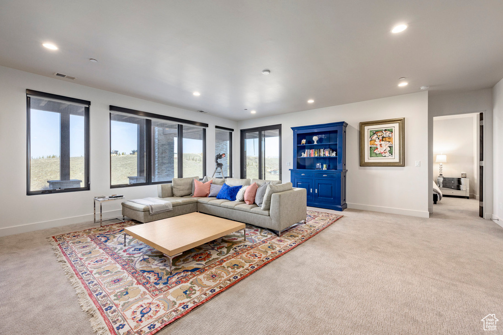 Living room with light colored carpet, baseboards, and visible vents