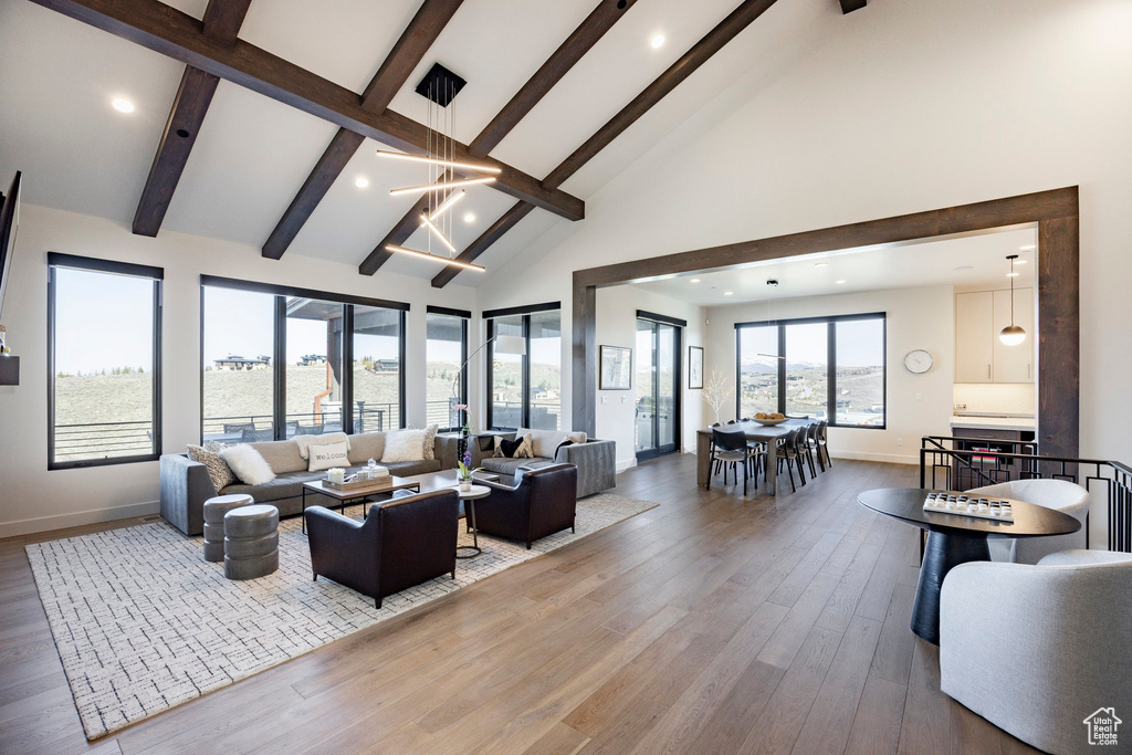 Living area featuring beamed ceiling, baseboards, and high vaulted ceiling