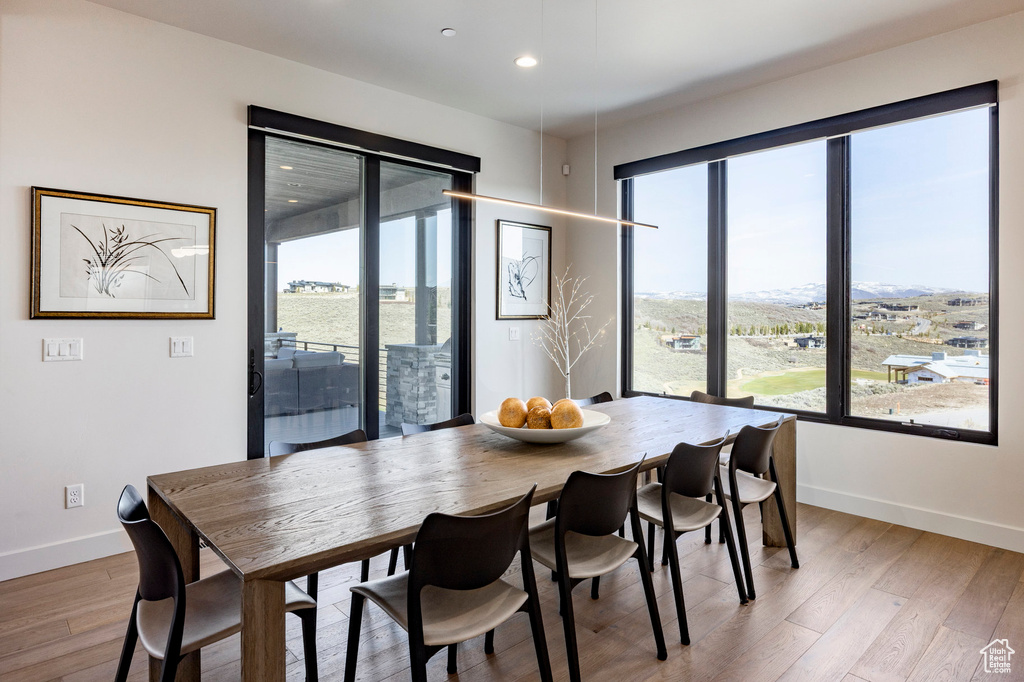 Dining space with baseboards, light wood-type flooring, plenty of natural light, and recessed lighting
