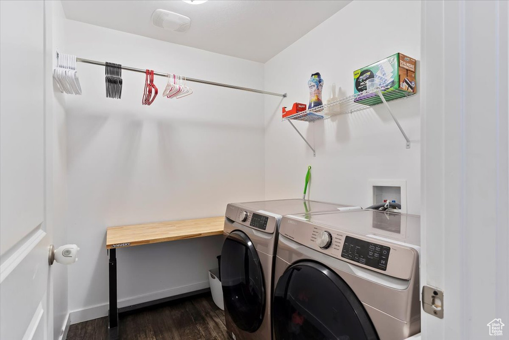 Laundry room featuring dark wood-type flooring, baseboards, washer and dryer, and laundry area