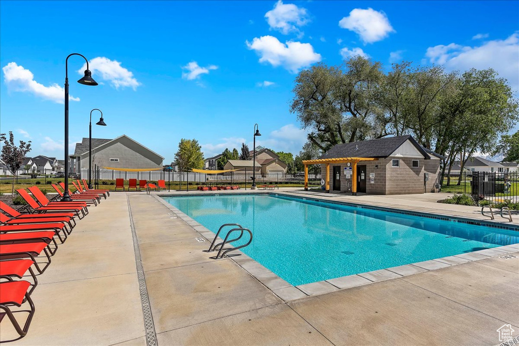 Pool with a residential view, a patio area, and fence