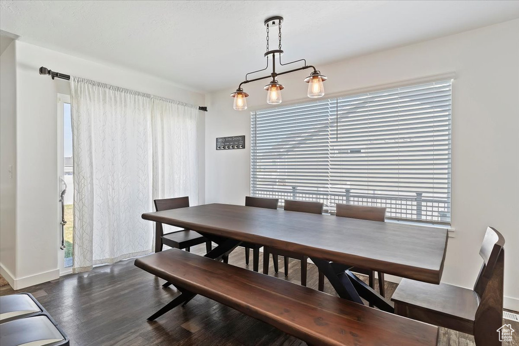 Dining room featuring dark wood-type flooring and baseboards