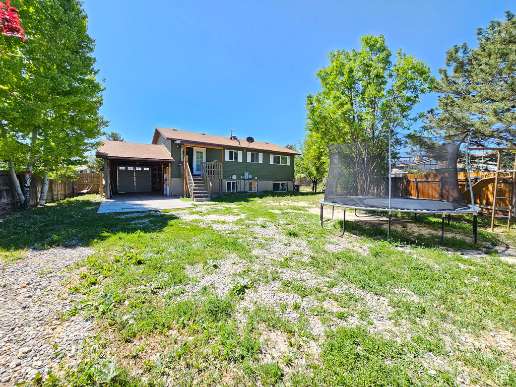 Rear view of property with a trampoline and an attached garage