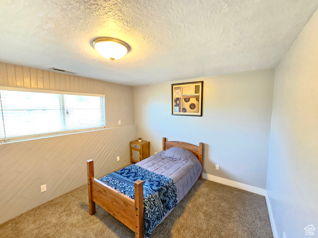 Bedroom featuring carpet and a textured ceiling