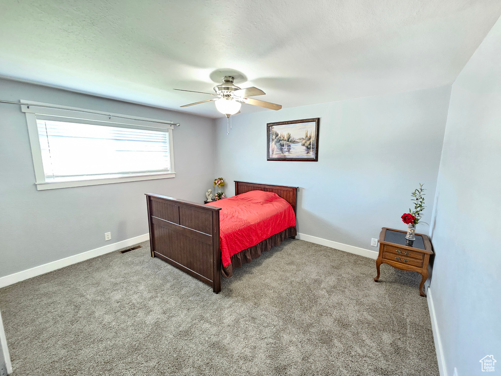 Carpeted bedroom featuring baseboards and a ceiling fan