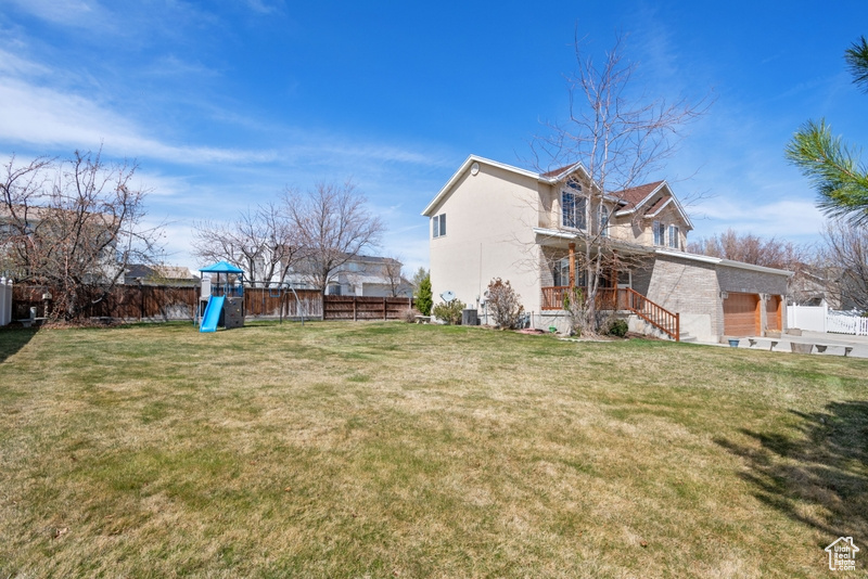 View of yard with fence and a playground