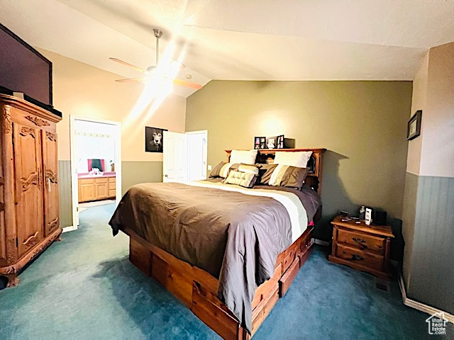 Carpeted bedroom with vaulted ceiling, ensuite bath, and ceiling fan