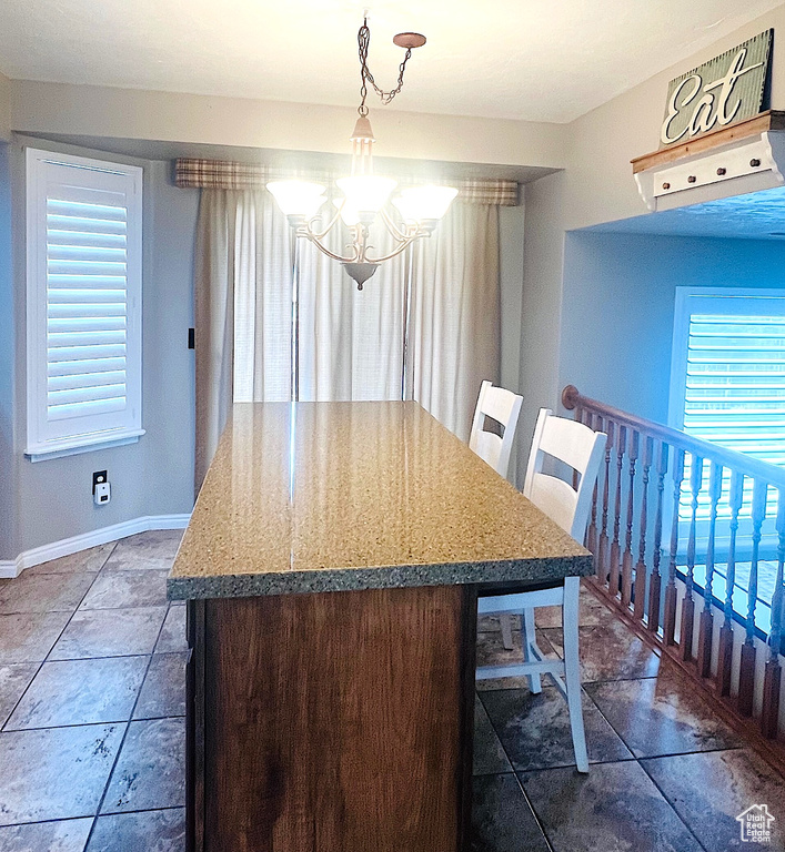 Dining room featuring baseboards and a notable chandelier