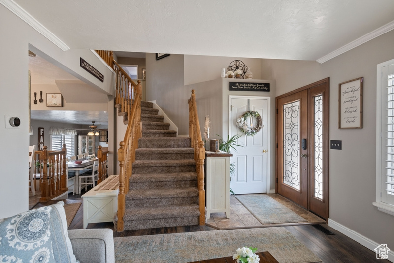 Entrance foyer with stairs, baseboards, crown molding, and wood finished floors