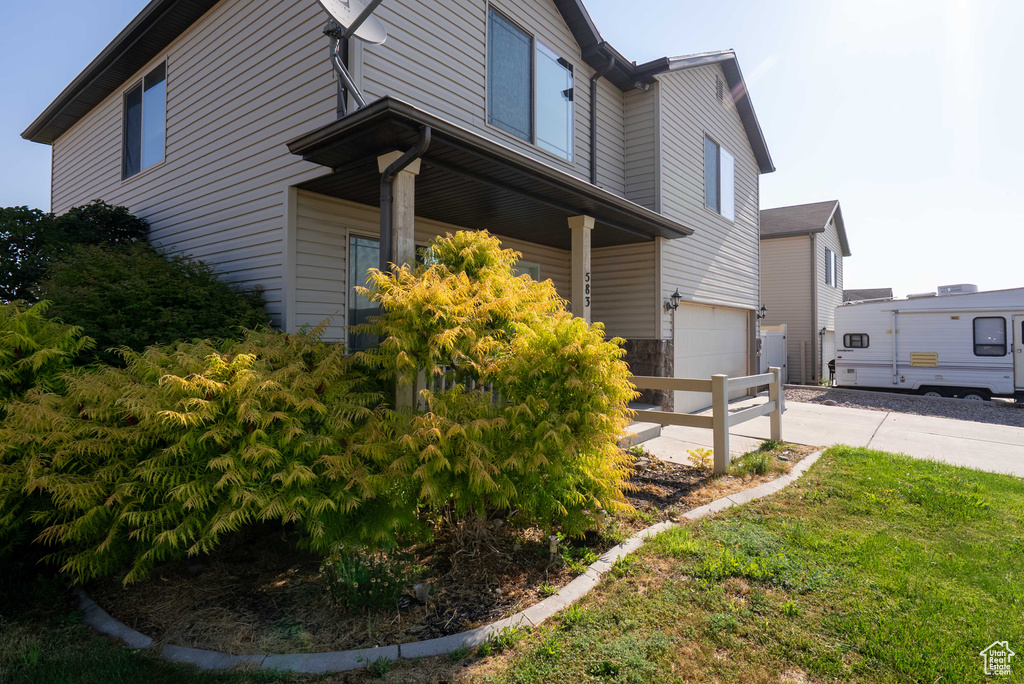 View of home's exterior featuring concrete driveway, covered porch, and a garage