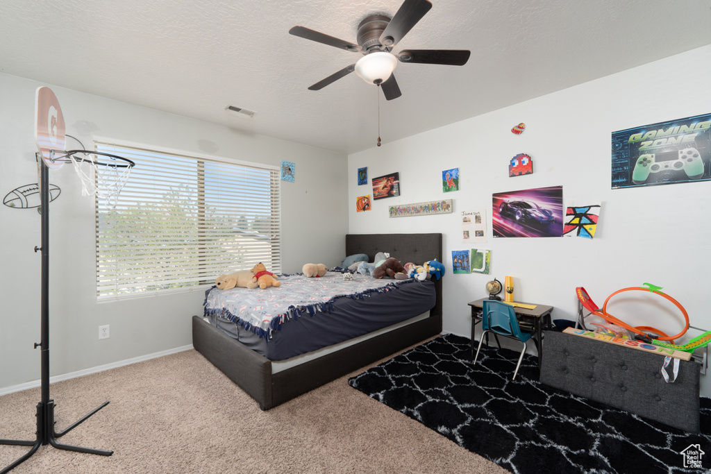 Carpeted bedroom featuring visible vents, ceiling fan, and baseboards