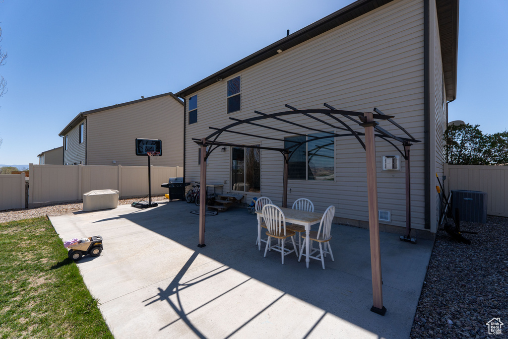 Back of property featuring a fenced backyard, central air condition unit, a patio, and a pergola