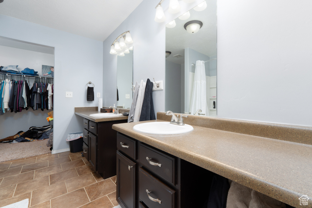 Full bath with a sink, two vanities, and a shower with curtain