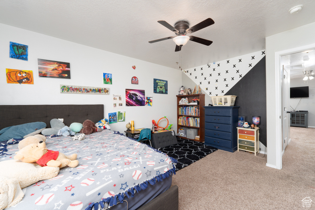 Carpeted bedroom featuring ceiling fan and baseboards