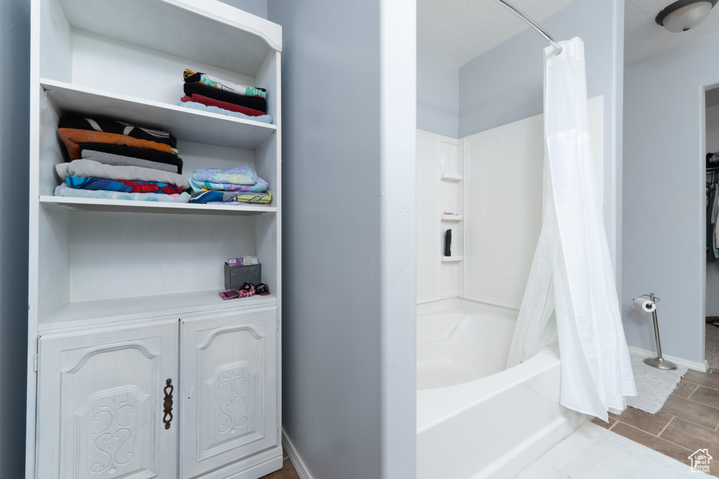 Full bath with shower / bathtub combination with curtain and baseboards